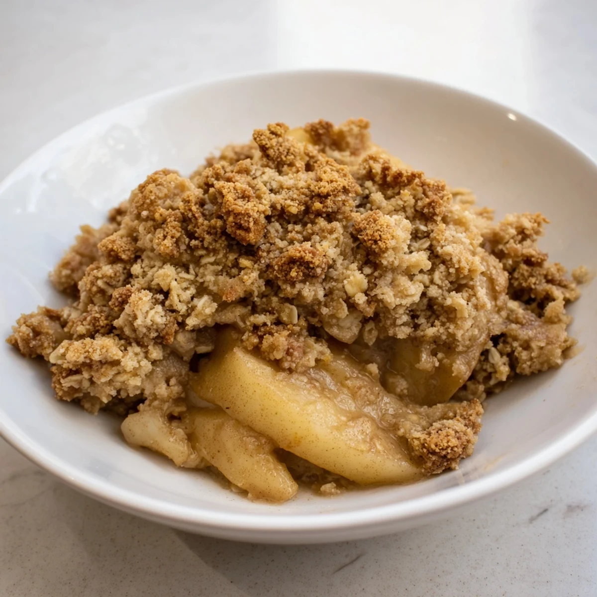 Warm, rustic apple and cinnamon crumble, bubbling hot from the oven, ready to serve with vanilla ice cream.