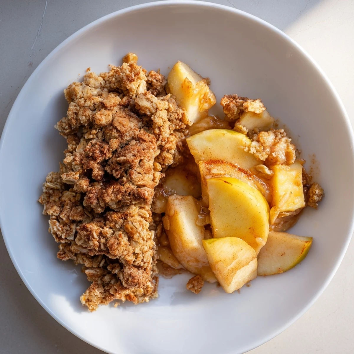 Golden-brown crumble topping blankets a warm, fruity filling featuring the delicious Rustic Apple and Cinnamon Crumble.