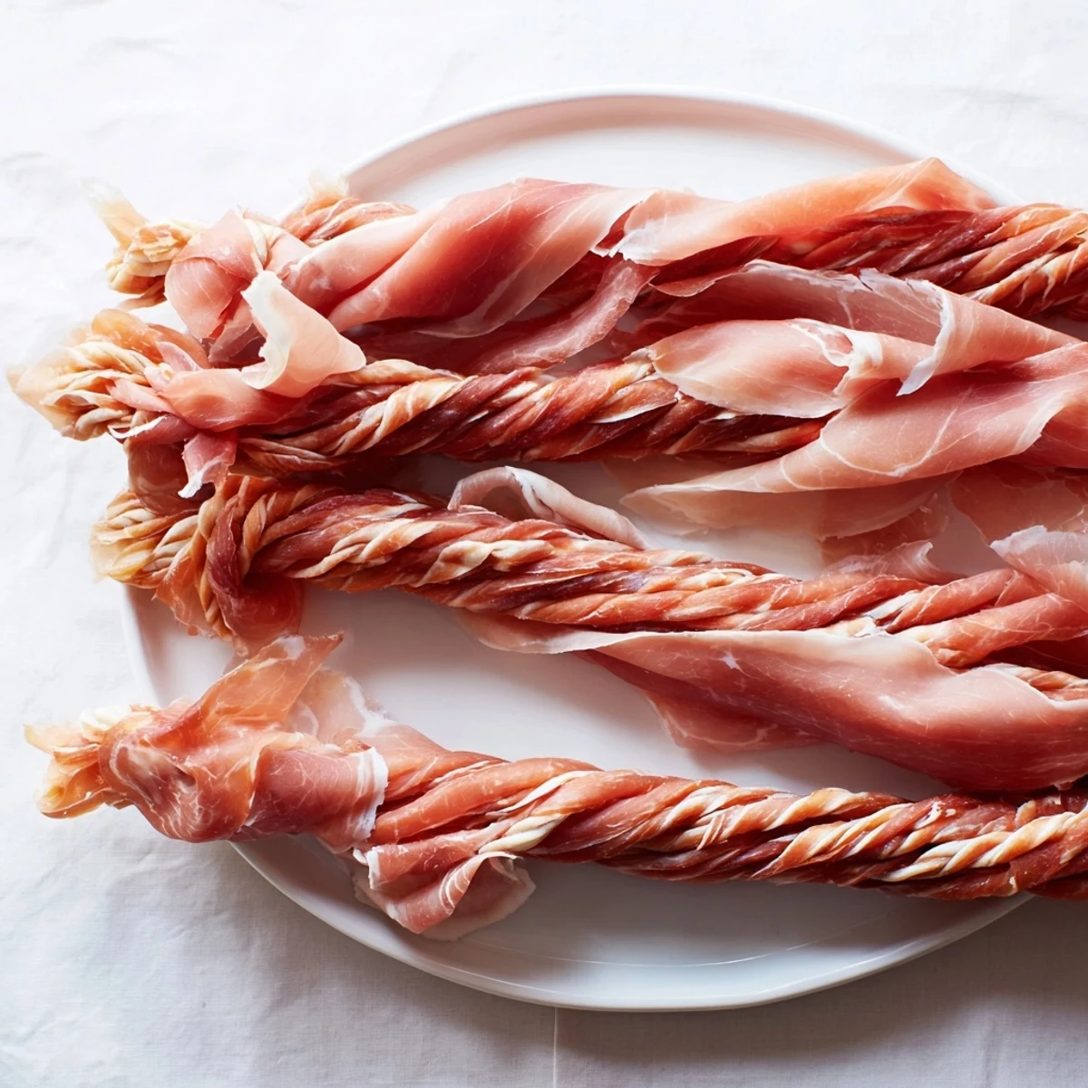 A close-up of a beautifully braided Nautical Knot, showcasing the salty prosciutto and cheesy threads.