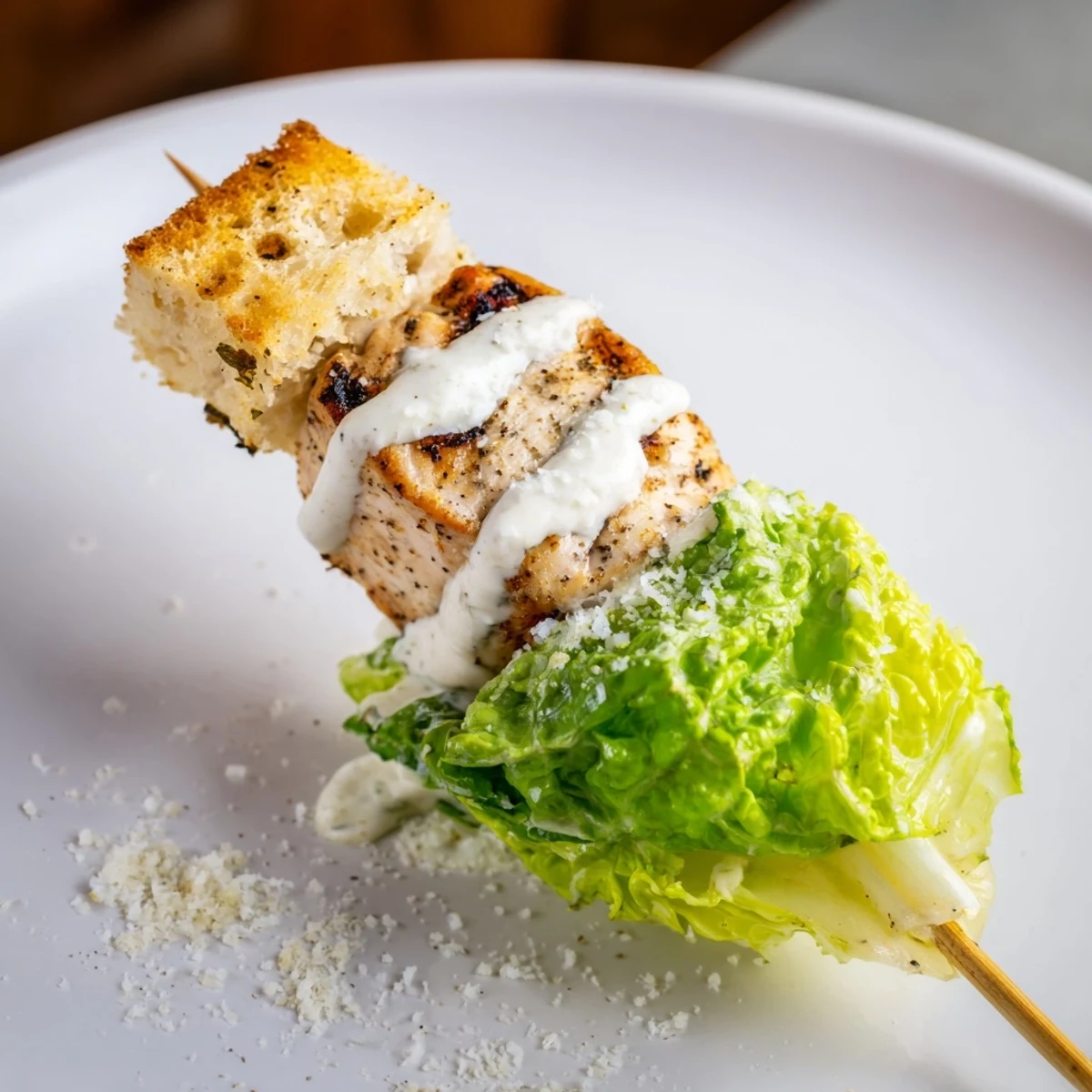 Grilled Chicken Caesar Salad Skewers served with drizzling creamy Caesar dressing, a delightful appetizer.