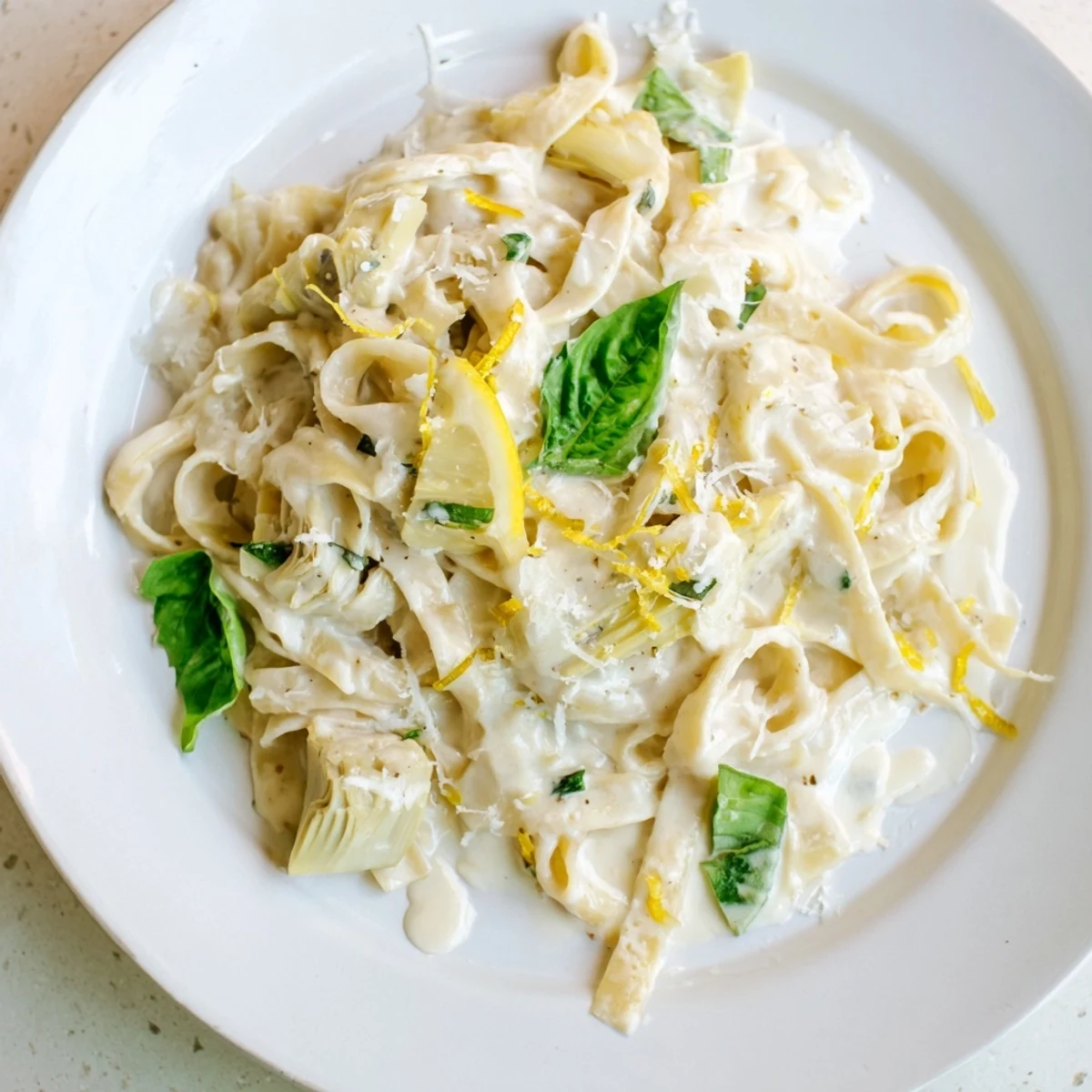 Close-up of golden creamy lemon artichoke pasta, a vegetarian Italian dish ready to serve.