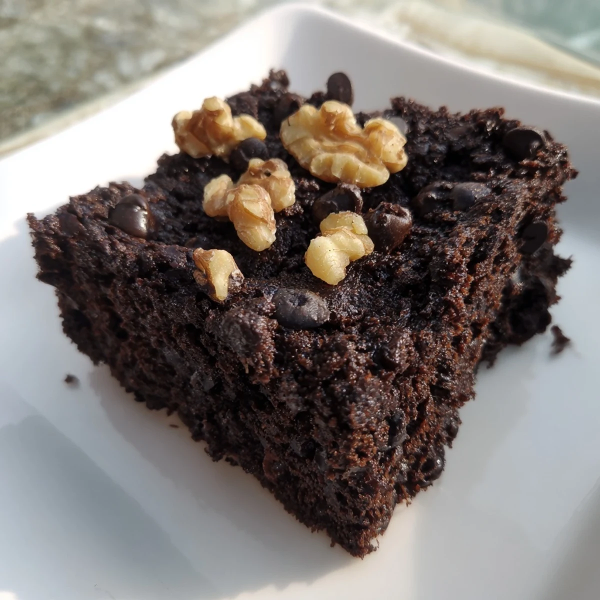 A plate of freshly baked black bean brownies, appealingly moist, ready for a gluten-free treat.