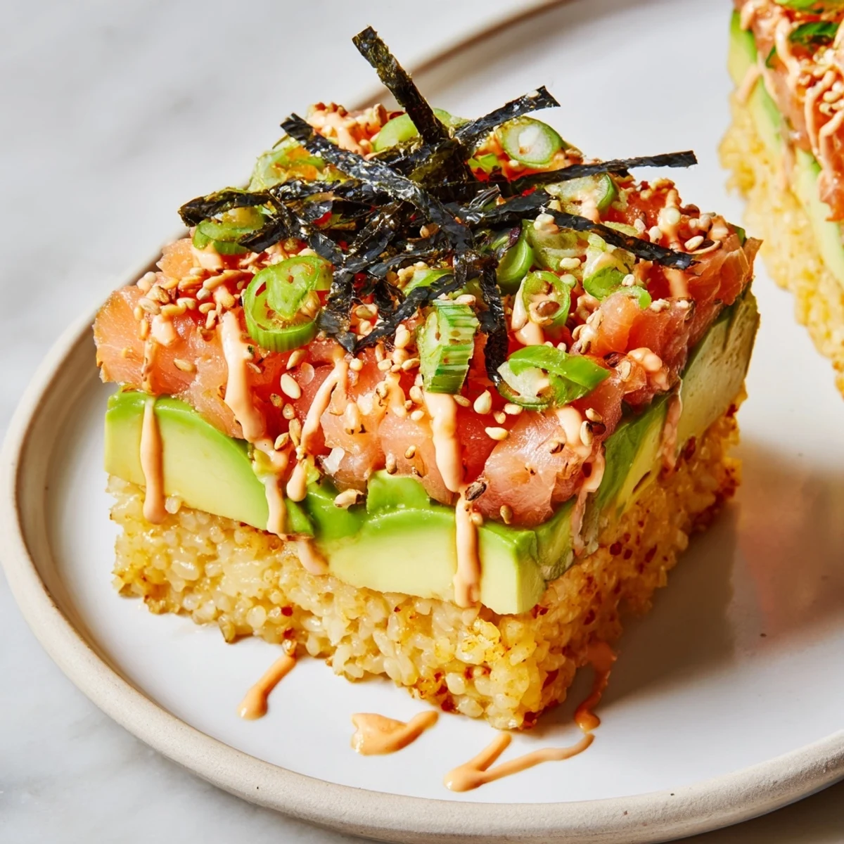 This image shows a beautifully stacked crispy rice salmon appetizer ready to eat, bursting with flavor.