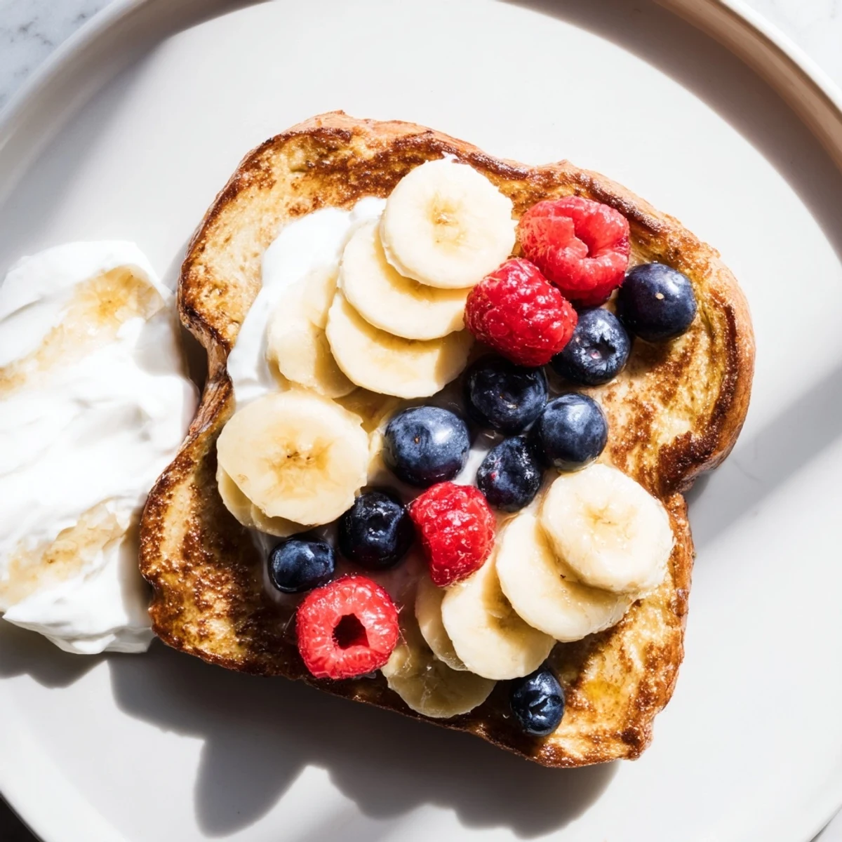 Golden-brown Protein French Toast, topped with fresh berries, offers a beautiful, healthy breakfast.