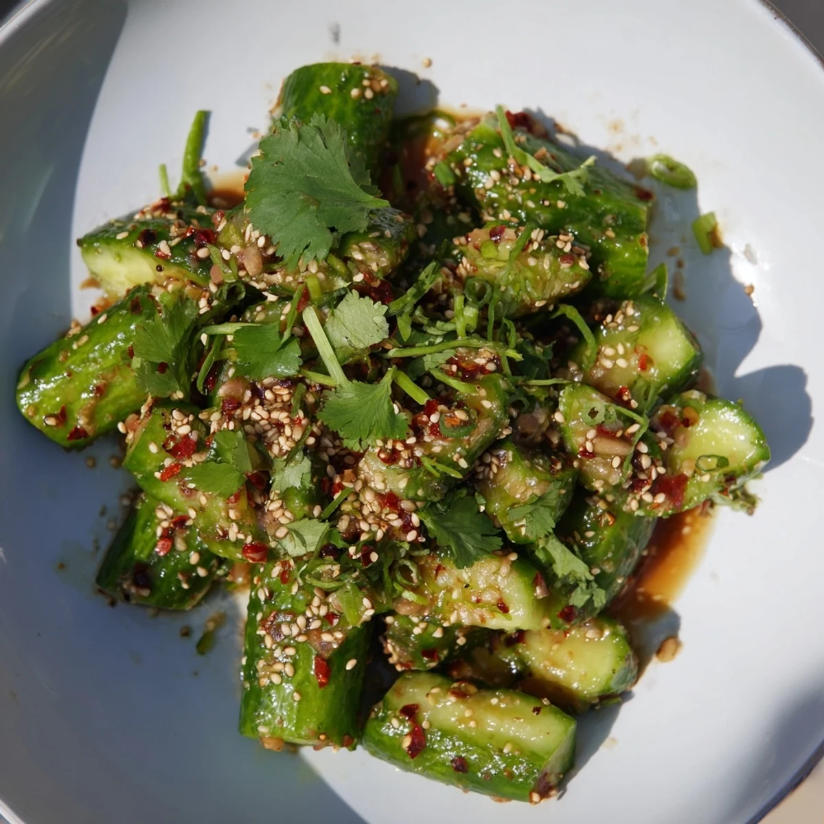 Fresh Chinese Spicy Smashed Cucumber Salad, a vibrant mix of flavors with sesame seeds and cilantro.