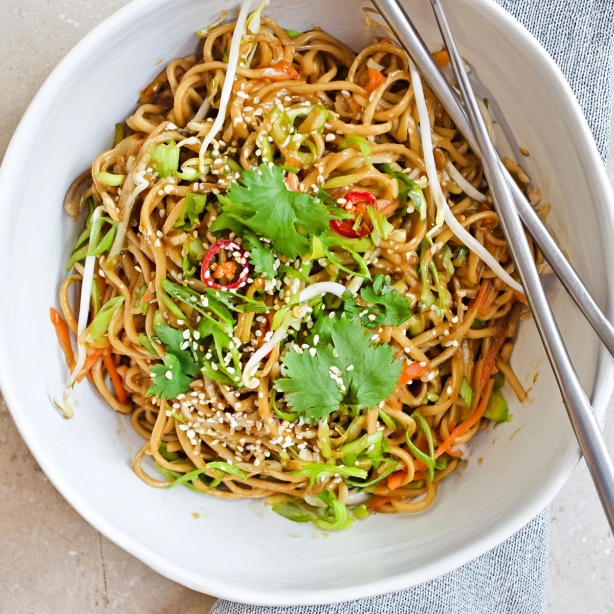 Steaming bowl of homemade Asian Garlic Noodle Bowl with toasted sesame seeds and fresh green onions.
