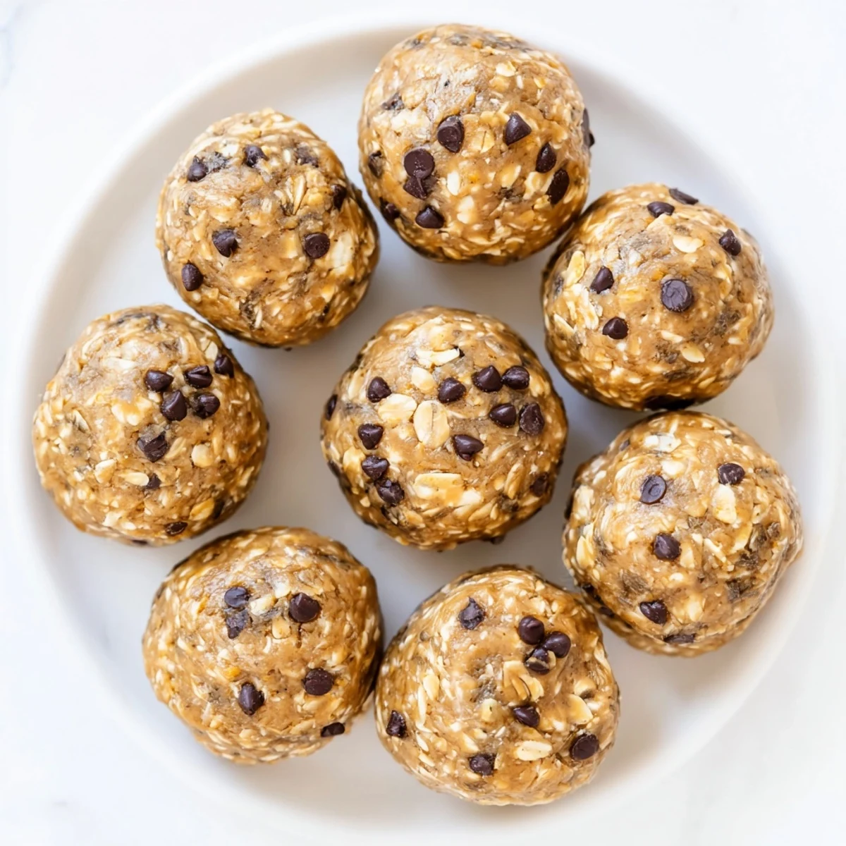 Close-up of freshly made Banana Chocolate Chip Energy Balls with mini chocolate chips and a hint of sea salt.