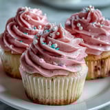 Freshly baked Pink Velvet Cupcakes with a tender crumb, served on a white ceramic plate for a celebration.