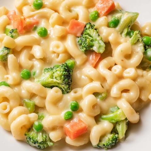 Bubbling hot Garden Veg Mac and Cheese with peas, broccoli, and carrots in a golden, cheesy sauce.