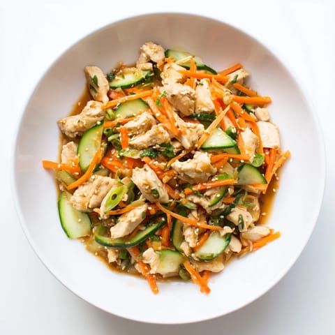 Close-up of the Deli Container Shaker Chicken Salad, featuring fresh cucumber and savory soy dressing.