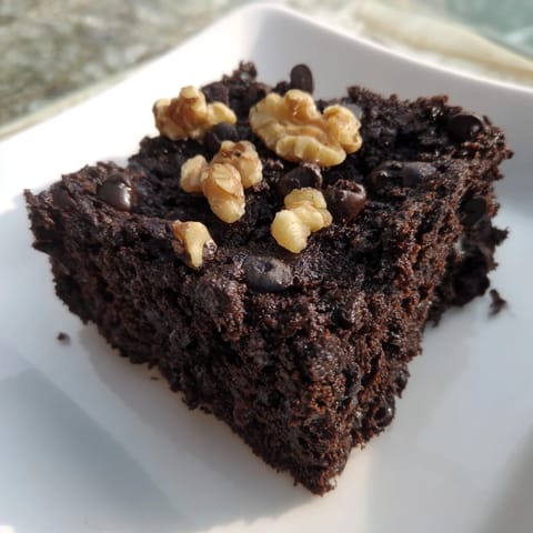A plate of freshly baked black bean brownies, appealingly moist, ready for a gluten-free treat.