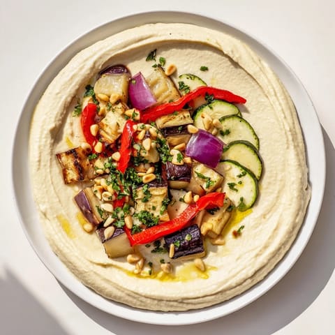 Vibrant Hummus Roasted Veggies, smelling of cumin, with golden pine nuts scattered across the dish.