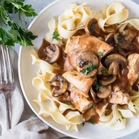 Creamy Chicken Marsala features tender chicken in a rich wine and mushroom cream sauce, garnished with parsley and Parmesan.  