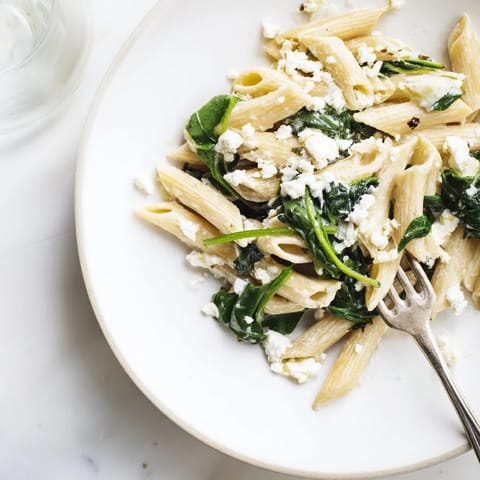 Steaming bowls of Creamy Feta Spinach Pasta, garnished with fresh herbs and lemon zest, offer a bright, satisfying vegetarian meal.