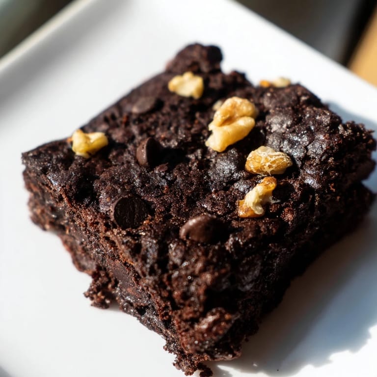 These decadent black bean brownies, perfect for dessert, feature visible chocolate chips and walnuts.