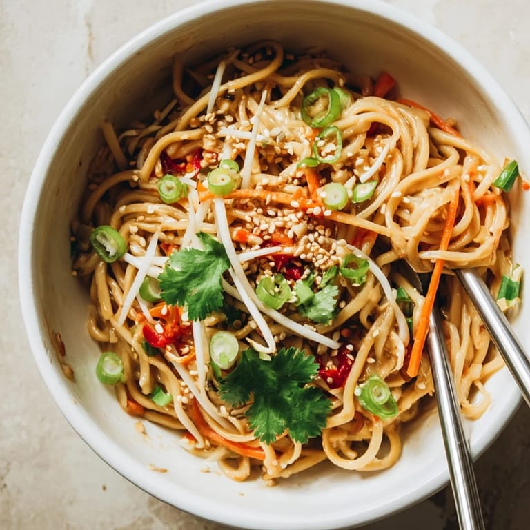 Glossy noodles coated in rich garlic-butter sauce, served with julienned carrots and crisp bean sprouts.