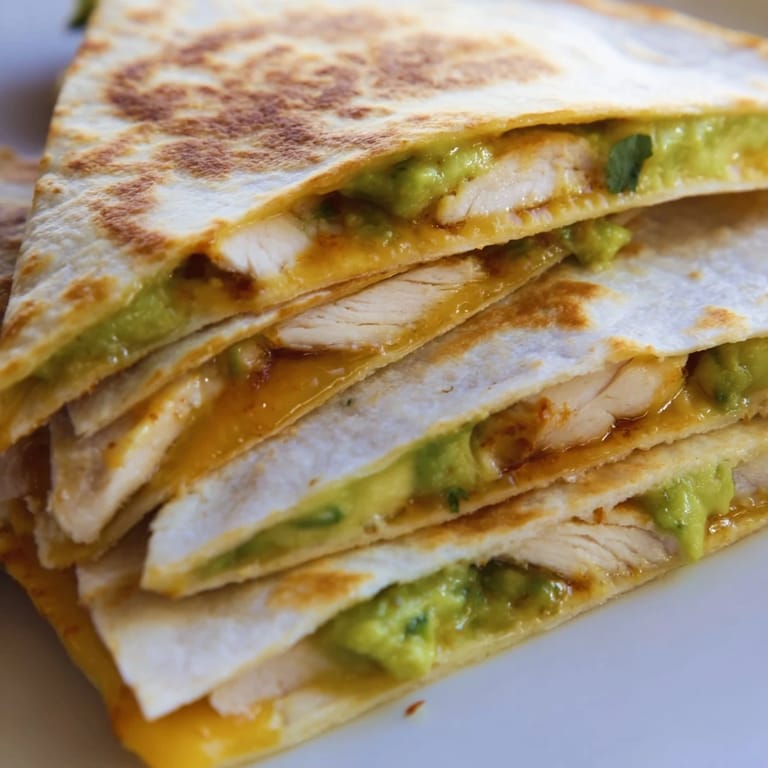 Perfectly melted cheese oozes from the edges of a freshly grilled Chicken Avocado Quesadilla served with salsa.