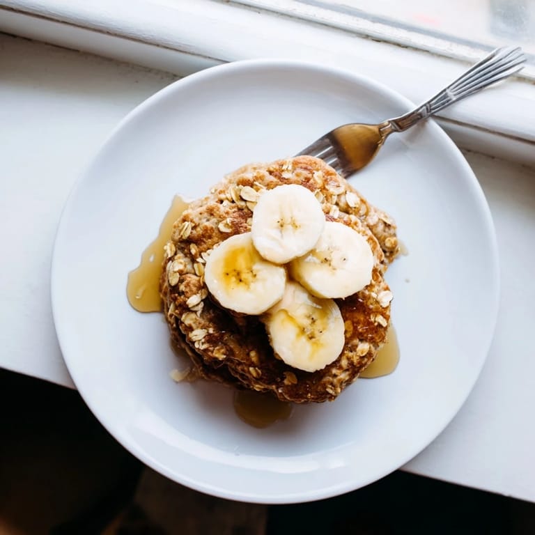 Golden Banana Oat Pancakes served with fresh berries and a dollop of yogurt for a wholesome breakfast.